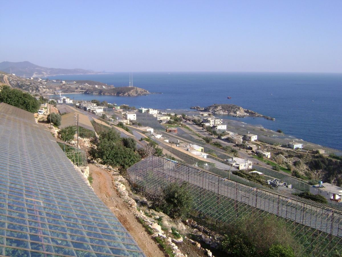 Aydıncık'ın Yenikaş kıyısında seralar, küçük bir yerleşim ve Akdeniz